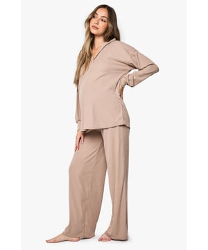 Ribbed maternity loungewear set featuring a collared top and wide-leg trousers
        Relaxed fit design with ample room for growing bump
        Soft ribbed texture for enhanced comfort during rest
        Elegant collar detail adds a refined touch to nightwear
        Wide-leg trousers with comfortable waistband for unrestricted movement
    
    This sophisticated maternity loungewear set combines style and comfort for expectant mothers. The ribbed texture creates a flattering silhouette while providing the stretch needed to accommodate your changing body. The collared neckline adds a touch of elegance to your nightwear collection, making this set perfect for both sleeping and relaxing at home. The wide-leg trousers offer unrestricted movement and comfort, essential during pregnancy. Pair with cosy slippers for the ultimate lounging experience, or throw on a lightweight dressing gown when answering the door. This versatile set will become a staple in your maternity wardrobe, offering the perfect balance of comfort and style during this special time.