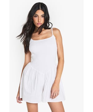 Crafted from soft cotton poplin for all-day comfort
        Flattering ruched bodice detail adds texture and dimension
        Feminine scoop neckline frames the dcolletage beautifully
        Relaxed fit shorts provide effortless movement
        Adjustable thin straps for a customised fit
    
    This charming cotton playsuit from Boohoo combines casual comfort with playful style. The ruched bodice creates a flattering silhouette while the scoop neckline adds a touch of femininity. Perfect for summer days, this versatile piece can be styled multiple ways-wear it with trainers and oversized sunglasses for daytime outings, or add a statement belt and knee-high boots for a festival-ready look as seen on our model. For family gatherings or brunches with friends, layer with a lightweight denim jacket and accessorise with delicate jewellery. The breathable cotton fabric ensures you'll stay comfortable throughout the day, making this playsuit an essential addition to your casual wardrobe.