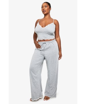 Delicate lace trim detailing along the neckline and hem for a feminine touch
        Comfortable jersey fabric that feels soft against the skin
        Flattering cami-style top with adjustable straps for the perfect fit
        Wide-leg trousers with drawstring waist for customisable comfort
        Two-piece set design allows for mix-and-match versatility
    
    Drift into dreamland in style with this charming plus-size pyjama set from Boohoo. The pretty lace detailing adds a touch of elegance to your nightwear collection, whilst the soft jersey fabric ensures maximum comfort throughout your slumber. The crop top design features a flattering sweetheart neckline that complements your curves, paired with relaxed wide-leg bottoms that allow for unrestricted movement as you lounge. Perfect for those cosy nights in or lazy weekend mornings, this set strikes the ideal balance between comfort and style. For chillier evenings, simply add a lightweight dressing gown to complete your nightwear ensemble. This versatile set is a must-have addition to your sleepwear rotation, offering both practicality and a hint of feminine charm.