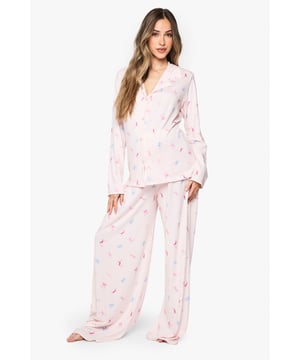 Maternity pyjama set featuring a charming bow print pattern throughout
        Classic button-through shirt design with notched collar for timeless nightwear style
        Relaxed fit with generous cut to accommodate your growing bump comfortably
        Full-length trousers with wide legs for unrestricted movement during sleep
        Long sleeves provide extra warmth and coverage for cooler evenings
    
    Drift into dreamland in absolute comfort with this delightful maternity pyjama set from Boohoo. Designed specifically for mums-to-be, this set combines practicality with style through its relaxed silhouette that grows with you throughout your pregnancy journey. The soft fabric feels gentle against sensitive skin, whilst the classic button-through design makes night feeds and bathroom breaks hassle-free. The wide-leg trousers offer ample room for movement, perfect for finding that elusive comfortable sleeping position. Pair with fluffy slippers and a warm dressing gown for those midnight kitchen trips, or simply lounge around on weekend mornings with a cup of tea and your favourite book. This set strikes the perfect balance between functionality and fashion, ensuring you look and feel your best during this special time.