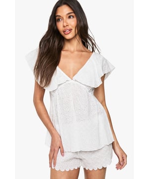 Delicate broderie anglaise fabric with intricate eyelet detailing throughout
        Feminine cami top with romantic V-neckline and charming frill overlay
        Relaxed fit design for ultimate comfort during your special night
        Matching shorts with scalloped hem for a coordinated bridal look
        Soft woven fabric that feels gentle against the skin
    
    Make your wedding night as special as your big day with this enchanting broderie anglaise pyjama set from Boohoo. The delicate eyelet detailing and feminine frills create a romantic aesthetic that's perfect for your bridal celebration. The flattering V-neckline and loose-fitting silhouette ensure both style and comfort as you unwind after your wedding festivities. Style with tousled hair and minimal jewellery for an effortlessly beautiful bridal nightwear look. This charming two-piece set strikes the perfect balance between comfort and elegance, making it an ideal addition to your wedding trousseau. The scalloped hem shorts complement the frill-detailed cami top beautifully, creating a cohesive set you'll treasure beyond your wedding night.