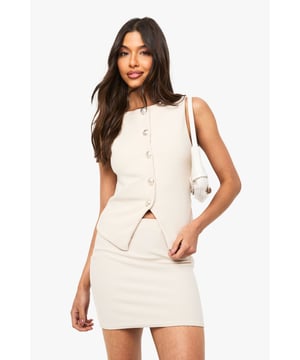 Textured A-line mini skirt with a flattering silhouette that sits perfectly on the hips
        Sleek, clean-cut design with a modern, minimalist aesthetic
        Versatile mini length that showcases your legs whilst maintaining a sophisticated edge
        Coordinating with a matching button-front sleeveless top for a chic co-ord look
        Structured fabric that maintains its shape throughout wear for a polished finish
    
    Make a statement with this textured A-line mini skirt from Boohoo, designed to turn heads on your next night out. The contemporary co-ord styling, as seen on our model paired with the matching sleeveless top, creates a fashion-forward ensemble that's perfect for the urban nightlife scene. The structured fabric offers a flattering fit that accentuates your silhouette whilst the mini length adds a flirtatious touch without compromising on style. Dress it up with strappy heels and a small handbag for drinks with the girls, or customise your look by pairing with a cropped blouse and statement jewellery for a sophisticated bar-hopping outfit. This versatile piece transitions effortlessly from casual meet-ups to more glamorous evening events, making it an essential addition to your going-out wardrobe.
