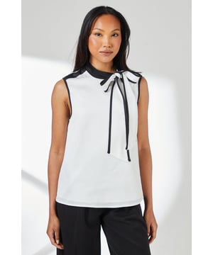Sleeveless satin top with striking contrast trim along the neckline and armholes
        Elegant tie-neck detail creates a sophisticated bow at the collar
        High neckline offers a refined silhouette perfect for formal settings
        Clean, straight-cut hemline for a polished finish
        Smooth woven fabric with a subtle lustre for an elegant appearance
    
    This Principles sleeveless top combines timeless elegance with contemporary design through its distinctive contrast detailing. The sophisticated tie-neck feature allows for versatile styling-wear it neatly tied for formal occasions or slightly loosened for a more relaxed interpretation. Pair with wide-leg trousers as shown for a chic monochromatic ensemble that transitions seamlessly from office to evening events. For formal occasions, style with a tailored blazer, statement earrings and court shoes. Alternatively, create a smart-casual look by teaming with slim-fit trousers and pointed flats. The clean lines and classic contrast colouring make this top an excellent foundation piece for multiple outfits, whether attending a wedding reception, business meeting, or sophisticated dinner engagement.