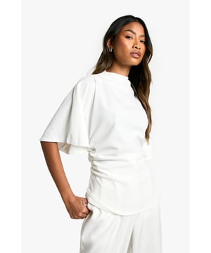 High neck design for a sophisticated look
        Wide, flowy sleeves add drama and movement
        Fitted waist creates a flattering silhouette
        Scuba crepe fabric offers structure and comfort
        Versatile piece suitable for various occasions
    
    Make a statement with this chic hochgeschlossene Jersey-Bluse aus Crepestoff. The high neck design exudes elegance, while the wide sleeves add a touch of drama to your ensemble. Perfect for the fashion-forward Boohoo girl who wants to stand out from the crowd. Style this versatile top with wide-leg trousers and statement earrings for a sophisticated look at family gatherings. For a more casual vibe, pair it with your favourite jeans and trainers. The fitted waist accentuates your figure, making it an ideal choice for both day and night events. Whether you're heading to a casual brunch or a night out with friends, this blouse will keep you looking effortlessly stylish. The scuba crepe fabric ensures comfort and structure, allowing you to move with confidence throughout your day.