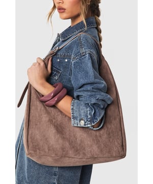 Soft faux suede shoulder bag with a spacious hobo silhouette
        Single adjustable shoulder strap for comfortable carrying
        Roomy interior perfect for everyday essentials
        Minimalist design with clean lines and no external embellishments
        Versatile shape that complements both casual and smart-casual outfits
    
    This faux suede shoulder bag combines practicality with effortless style. The slouchy hobo design offers ample space for your daily necessities whilst maintaining a relaxed aesthetic that works brilliantly with your everyday wardrobe. As shown, pair with denim for a classic daytime look, or match with floaty dresses and ankle boots for weekend brunches. The neutral tone makes it an ideal companion for autumn/winter layering or spring transitional outfits. Perfect for shopping trips, coffee dates or casual workdays, this Boohoo bag strikes the balance between functionality and fashion. The minimalist design ensures it won't compete with your outfit but rather complement it, making this an essential addition to your accessories collection that will serve you season after season.