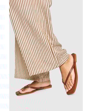 Sleek square-toe design for a contemporary twist on classic flip-flops
        Flat heel (under 2cm) ensures all-day comfort without compromising style
        Minimalist thong strap crafted for durability and comfort
        Versatile design perfect for pairing with both casual and holiday attire
        Lightweight construction ideal for packing in your holiday suitcase
    
    These square-toe flip-flops from Boohoo offer the perfect blend of modern design and everyday wearability. The clean lines and minimalist aesthetic make them an essential addition to your summer wardrobe. Style them with flowing wide-leg trousers as shown for a relaxed daytime look, or pair with a breezy sundress for casual gatherings. They're particularly brilliant for beach holidays, poolside lounging, or weekend brunches when comfort is key. The understated design ensures they'll complement virtually any casual ensemble, while the durable construction means they'll see you through countless summer adventures. These flip-flops strike the perfect balance between practicality and style - a true warm-weather essential that will quickly become your go-to footwear for laid-back occasions.