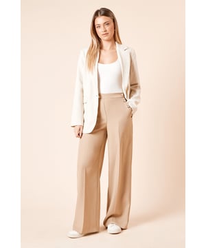 Striking military-inspired button detailing along the waistband for a distinctive touch
        Flattering wide-leg silhouette that creates a flowing, elegant line
        High-waisted design that enhances your natural shape
        Smooth woven fabric with a touch of stretch for all-day comfort
        Clean-lined back with a sleek pocket detail for a polished finish
    
    These sophisticated wide-leg trousers blend contemporary styling with classic military-inspired detailing for a versatile wardrobe essential. The decorative buttons along the waistband create visual interest while the flowing wide-leg cut offers both comfort and elegance. Style them as seen with a simple white top and matching blazer for a coordinated daytime look perfect for brunches or casual office days. For weekend gatherings, pair with a soft knit jumper and trainers for an effortlessly chic ensemble. The high-waisted design works beautifully with tucked-in blouses or cropped tops, while the stretch-enhanced fabric ensures these trousers move comfortably with you throughout the day. A perfect addition to your collection for family gatherings, coffee dates, or casual Friday workwear.
