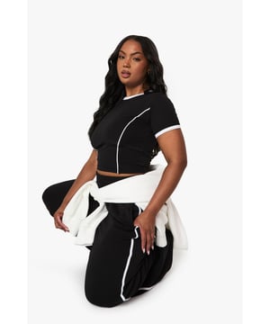 Soft cotton fabric for all-day comfort and breathability
        Distinctive contrast piping detail along the seams for a sporty aesthetic
        Cropped t-shirt with contrasting trim around the neckline and sleeves
        Straight-leg joggers with side piping for a flattering silhouette
        Versatile two-piece set that can be styled together or separately
    
    This contemporary tracksuit set brings together casual comfort and street style flair. The cropped t-shirt features eye-catching piping detail that continues onto the straight-leg joggers, creating a coordinated look that's both relaxed and put-together. Perfect for weekend brunches or casual meet-ups with friends, this set can be dressed up with chunky trainers and a crossbody bag for daytime outings. For cooler evenings, layer with the white jacket as shown on our model for added warmth and contrast. The straight-leg cut of the joggers offers a more refined silhouette than traditional tapered styles, making this set suitable for coffee dates or casual shopping trips. Mix and match with other wardrobe staples to maximise your styling options - pair the joggers with a fitted bodysuit or team the crop top with high-waisted jeans for effortless versatility.
