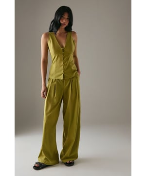 Tailored wide-leg silhouette with a dramatic flowing drape
        Elegant front pleats for added structure and dimension
        Distinctive side tie detail with decorative buttons for a feminine touch
        High-rise waistband designed to flatter the natural waistline
        Linen blend fabric offering breathability and a natural textured finish
    
    These statement trousers from Warehouse combine sophistication with contemporary flair. The wide-leg design creates a striking silhouette that moves beautifully with every step, whilst the tailored pleats add structure and refinement. Style with a simple white tee and flat sandals for effortless daytime chic, or pair with the matching waistcoat for a coordinated ensemble that's perfect for summer gatherings. The versatile design transitions seamlessly from casual brunches to family celebrations - simply swap your trainers for leather slides and add delicate jewellery to enhance the look. The linen blend fabric ensures these trousers remain comfortable throughout the day, making them an essential addition to your warm-weather wardrobe.