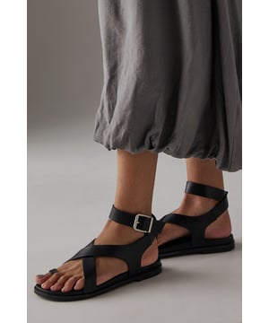 Stylish toe loop design for a secure and comfortable fit
        Adjustable ankle strap with metal buckle fastening for a customised fit
        Flat footbed with cushioned insole for all-day comfort
        Cross-over straps create an elegant silhouette
        Durable outsole with subtle tread for reliable grip
    
    The Faith Mannie sandals combine contemporary design with everyday practicality. The distinctive toe loop and cross-over straps create a modern silhouette that pairs beautifully with flowing dresses, as shown by our model, or relaxed linen trousers for effortless summer style. With their flat heel measuring under 2cm, these sandals offer the perfect balance of comfort and sophistication for long summer days. The adjustable ankle strap ensures a secure fit whilst adding a refined detail to this casual footwear essential. Ideal for family gatherings, weekend brunches or holiday strolls, these versatile sandals will quickly become your warm-weather staple. Their faux leather finish gives them a polished appearance that transitions seamlessly from daytime casual to relaxed evening occasions.