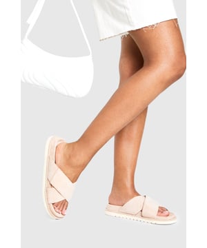 Distinctive cross strap design for a contemporary twist on classic footbed sliders
        Cushioned footbed providing all-day comfort for casual wear
        Flat heel measuring between 0-2cm, perfect for effortless walking
        Textured sole offering reliable grip on various surfaces
        Faux suede finish adding a touch of sophistication to a casual staple
    
    These cross strap footbed sliders combine style and practicality for your everyday wardrobe. The minimalist design features soft faux suede straps that gently hug your feet while the cushioned footbed ensures comfort with every step. Pair them with frayed hem denim shorts and an oversized linen shirt for a relaxed weekend brunch, or style with a flowing maxi dress for garden parties and seaside strolls. Their versatility extends to poolside lounging, where they make the perfect companion to your favourite swimwear. The neutral aesthetic allows these sliders to complement virtually any casual ensemble, making them an essential addition to your summer rotation. Their durable construction means they'll remain a faithful companion throughout the warmer months, ready to slip on whenever comfort calls.