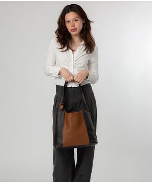 The 'Renata' shoulder bag from NiNa Amora elevates this design with the natural leather exeterior with a soft to the touch pebble grain finish. A open-top design gives it a relaxed slouchy look and conceals the spacious main compartment. This is comnplemented by a zipped pocket on the lined interior for a robust finish. A chunky single handle adorns this style and makes it comfortable to wear all day long. This is all finished with the NiNa Amora X logo embossed in stunning silver foil on the front and hanging charm for a luxurious finishing touch.