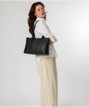 As part of the NiNa Amora range, the 'Maria' tote bag is inspired by our designer's daughter and all about elevating classic designs with high quality leather. The spacious main compartment is lined for a flawless finish and secured with a zip-over top which conceals a slip and zipped pocket; perfect for maintaining an organised accessory. Additional storage is provided by a slip pocket to the rear of the item - ideal for on-the-go storage. Two slim leather handles adorn the style with a drop length of 30cm which are complemented by silver metal fittings and zips give this design a elegant look pops against the leather exterior. The NiNa Amora x logo is silver foil embossed on the front and hanging charm for a luxurious finishing touch.