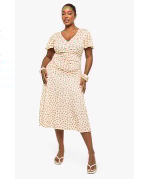 Flattering ruched detailing across the bodice for a figure-enhancing silhouette
        Feminine flutter sleeves adding movement and softness to the overall look
        Elegant V-neckline that frames the dcolletage beautifully
        Flowing midi-length skirt with gentle flare for ease of movement
        Versatile mesh fabric that drapes gracefully over curves
    
    This charming plus-size midi dress from Boohoo combines comfort with effortless style. The thoughtfully placed ruching creates a flattering shape while the delicate flutter sleeves add a touch of romance. Perfect for day-to-night versatility, pair with strappy sandals and a clutch as shown for daytime gatherings, or transform your look with statement jewellery and heeled boots for evening occasions. The flowing midi length offers both sophistication and practicality, making it ideal for office wear with a tailored blazer or weekend brunches with a denim jacket. The all-over pattern adds visual interest without overwhelming, whilst the V-neckline creates a balanced silhouette. This dress embodies Boohoo's commitment to inclusive fashion that transitions seamlessly between casual and more formal settings.