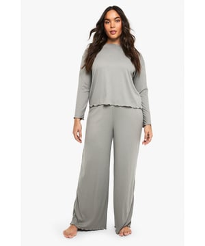 Ribbed texture throughout for added comfort and visual interest
        Relaxed long-sleeve top with distinctive ruffle-trimmed hem
        Wide-leg trousers with matching ruffle detail at the hem
        Soft, stretchy fabric ensures unrestricted movement
        Inclusive plus-size design that flatters your natural silhouette
    
    Embrace laid-back luxury with this Boohoo ribbed loungewear set, thoughtfully designed for those moments when comfort is non-negotiable but style remains essential. The top features a relaxed fit with a playful ruffled hem that adds a feminine touch to casual wear, while the coordinating wide-leg trousers create a balanced silhouette that moves beautifully with you. Perfect for weekend brunches at home, film nights with friends, or simply unwinding after a busy day. Layer with a chunky cardigan and fluffy slippers during colder months, or wear the top with your favourite denim for a quick dash to the shops. This versatile set transitions effortlessly between lounging and casual outings, making it an indispensable addition to your off-duty wardrobe.