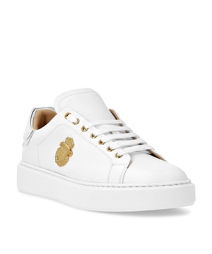 Deze low-top sneakers stralen verfijnde elegantie uit met een eigentijdse twist en herdefiniëren casual luxe met kenmerkende details en uitzonderlijk vakmanschap.   Vervaardigd van eersteklas rundleer met een vleugje nubuck voor een gladde, verhoogde afwerking.   Handtekeningembleem in metallic detail voegt een opvallend statement toe.   Lederen voering zorgt voor luxueus comfort en ademend vermogen.   Onberispelijke constructie biedt een slank silhouet en moderne proporties.   Perfect om alledaagse looks op te waarderen met een vleugje verfijnde charme.