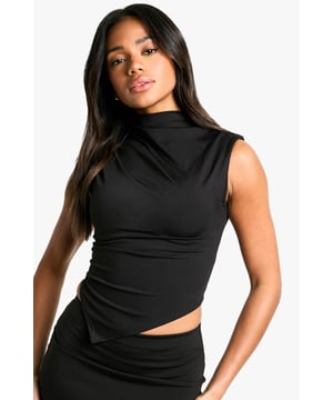 High neck design for a sophisticated look
        Sleeveless style perfect for layering or wearing solo
        Asymmetrical hem adds a unique twist
        Figure-hugging fit accentuates curves
        Cropped length ideal for pairing with high-waisted bottoms
    
    Make a statement in this striking high-neck top from Boohoo. The asymmetrical hem creates visual interest and sets you apart from the crowd, while the sleeveless design keeps you cool on the dance floor. Perfect for a night out, this versatile piece can be dressed up or down to suit your mood. Pair it with a sleek midi skirt and strappy heels for a chic club ensemble, or team it with high-waisted trousers and a blazer for drinks at an upscale bar. The figure-hugging fit flatters your silhouette, making it an ideal choice for those who want to turn heads. Accessorise with bold earrings and a clutch bag to complete your look. Whether you're meeting friends or heading to a new hotspot, this top ensures you'll be ready for whatever the night brings.