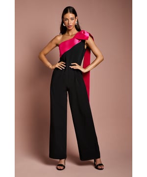 One-shoulder design with a dramatic bow detail
Wide-leg jumpsuit silhouette with a flattering waist tie
crepe fabric with a luxurious drape
Sleeveless bodice with a fitted waist
Full-length wide legs for an elegant, flowing look

Exuding sophistication and glamour, this jumpsuit is a showstopping choice for formal occasions. The one-shoulder neckline with a striking bow detail adds a touch of drama, while the crepe fabric drapes beautifully for a refined look. Style it with statement jewellery and heels for a wedding or evening event, or pair it with a fascinator and clutch for a day at the races. With its flattering waist tie and flowing wide legs, this jumpsuit is sure to turn heads and make a lasting impression.