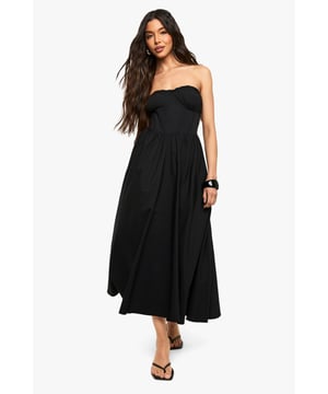 Elegant bandeau neckline with subtle ruching detail for a flattering silhouette
        Fitted bodice transitions into a flowing skater skirt for effortless movement
        Midaxi length offers versatile styling options for various occasions
        Strapless design showcases shoulders and dcolletage beautifully
        Structured woven fabric provides shape retention throughout wear
    
    This bandeau skater midaxi dress from Boohoo combines casual comfort with chic styling. The strapless design creates a fresh summer look that can be dressed up or down depending on the occasion. For daytime outings, style as shown with minimal flat sandals and a compact shoulder bag for an effortlessly cool aesthetic. Add a denim jacket for cooler evenings or layer with a cropped cardigan for family gatherings. The versatile midaxi length works brilliantly for garden parties or casual brunches with friends. For a more polished look, pair with delicate jewellery and a sleek updo. The flowing skater silhouette flatters all body types while offering comfortable movement throughout the day. This wardrobe essential transitions seamlessly from casual daywear to evening drinks with a simple change of accessories.