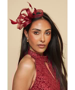 Elegant headband featuring intricate loop detailing and delicate feather embellishments
        Sculptural design creates a striking silhouette perfect for formal occasions
        Lightweight construction ensures comfortable wear throughout the day
        Secure fit with discreet attachment that keeps the headpiece perfectly positioned
        Versatile accessory that complements both updos and flowing hairstyles
    
    Add a touch of sophistication to your occasion ensemble with this exquisite loop and feather headband from Wallis. The artfully arranged loops create a dimensional effect that catches the light beautifully, while the feather accents add movement and drama. As shown, it pairs wonderfully with elegant wrap dresses for a coordinated look that's perfect for weddings, race days and formal garden parties. The headband sits comfortably at an angle, creating a flattering frame for your face without overwhelming your overall appearance. Style with sleek, polished hair for classic refinement, or contrast with loose waves for a more contemporary approach. This statement piece negates the need for elaborate jewellery - simply add delicate earrings to complete your glamorous occasion look.