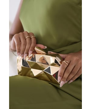 Turn heads with this striking Rica geometric clutch bag, designed to make a bold fashion statement at any evening event. The angular, high-gloss surface creates a modern 3D effect that reflects light from every angle. Its compact hard case keeps essentials secure while offering standout style. Perfect for weddings, parties, or night outs. Key Features: • Material: High-shine acrylic hard case with faceted geometric design • Dimensions: 18cm (L) x 9cm (H) x 6cm (W) • Fastening: Top snap clasp closure • Detail: Unique polygonal surface with a sculptural silhouette