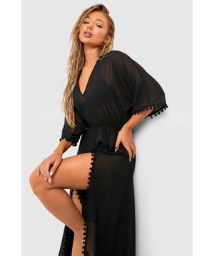 Chiffon maxi kaftan with plunging neckline
        Playful pom pom trim along sleeves and side splits
        Flowy silhouette with cinched waist for a flattering fit
        Dramatic side splits for ease of movement
        Versatile beachwear piece for various summer occasions
    
    Make a statement on your next beach getaway with this eye-catching maxi kaftan. The lightweight chiffon fabric drapes beautifully, creating an effortlessly chic silhouette that's perfect for warm-weather lounging. The plunging neckline adds a touch of allure, while the cinched waist accentuates your figure. The playful pom pom detailing along the sleeves and side splits injects a fun, bohemian vibe into this beach essential. Whether you're strolling along the shore, sipping cocktails by the pool, or attending a beachside soire, this kaftan is your go-to piece for stylish summer dressing. Layer it over your favourite swimwear for instant glamour, or pair it with strappy sandals and statement earrings for a chic evening look. This versatile kaftan is a must-have addition to your holiday wardrobe, promising to keep you looking fabulous from sunup to sundown.
