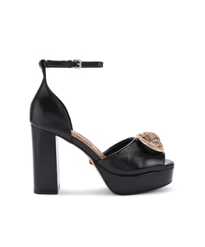 This pair of Kurt Geiger Chelsea Platform Sandals feature a black leather upper. The toe strap is adorned with shiny brass eagle head sat in a buckle, all embellished with crystals. Heel height: 11cm. Platform height: 3cm. Pitch height: 8cm.