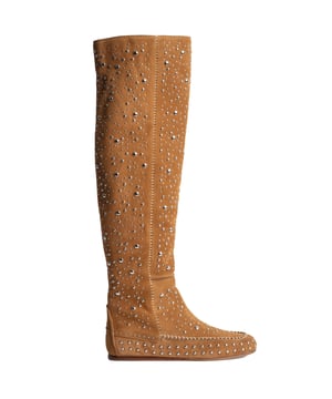 Kniehoge laarzen met studs van Zadig & Voltaire - opvallende stijl met bohemien flair.\n\n De kniehoge laarzen van Zadig & Voltaire herinterpreteren de boho-stijl met een opvallend en onmiskenbaar ontwerp. Deze laarzen zijn gemaakt van hoogwaardig suède en combineren de warmte van natuurlijke materialen met de glamour van honderden metallic studs die het oppervlak sieren.\n\n De hoge schacht omsluit het been op elegante wijze, terwijl het platte mocassin-achtige ontwerp zorgt voor comfort zonder afbreuk te doen aan de stijl. Door de zijsluiting met interne rits zijn ze gemakkelijk aan te trekken en het gestructureerde silhouet stroomlijnt de look van de outfit.\n\n Details:\n - Type schoen: Platte hoge laars.\n - Materiaal buiten: Zacht suède.\n - Binnenvoering: Textiel.\n - Details: Metalen stud applicaties over de hele laars.\n - Sluiting: Binnenrits aan de zijkant.\n - Zool: Dun en flexibel rubber.\n - Hoogte: Knielengte (kan dankzij de flexibiliteit ook wat langer gedragen worden).\n - Ze worden geleverd met een stofzak.\n\n Met deze laarzen vindt Zadig & Voltaire de perfecte balans tussen rebellie en elegantie. Een gedurfde keuze voor vrouwen die een statement willen maken met hun eigen stijl.\n Samenstelling: Buitenmateriaal: suède; Binnenmateriaal: leer; Zool: synthetisch\n Onderhoud:\nReinigen met een zachte, droge doek.\n Vermijd contact met water, parfum of schuurmiddelen.\n Droog en geventileerd bewaren.