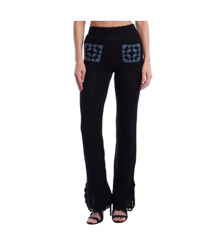Deze opengewerkte gebreide broek met een getailleerd silhouet op de heupen en uitlopende zoom combineert een bohemian stijl met handgemaakte details. De broek heeft contrasterende zakken aan de voorkant en een metallic ritssluiting aan de achterkant met een merkopdruk. De open weving maakt het een koel kledingstuk, perfect voor de warmere maanden of als gewaad voor strandlooks.\n\n Details:\n - Snit: Flare (smal bij de benen, uitlopend aan de onderkant).\n - Buitenkant: Ongevoerde opengewerkte gebreide stof.\n - Sluiting: Metalen zijrits met gegraveerd schuifje.\n - Stijl: Bohemian, met decoratieve gehaakte zakken.\n - Functionaliteit: Lichtgewicht en opvallend kledingstuk, ideaal voor warme klimaten.\n\n Opvallende strandbroek die textuur en beweging toevoegt aan elke outfit, ideaal voor wie wil opvallen met een casual boho-look.\n Samenstelling: 100% katoen\n Onderhoud:\nHandwas in koud water. Niet in de droger drogen. Plat drogen. Niet rechtstreeks op de details strijken.