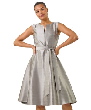 Jacquard Belted Fit & Flare Dress from Roman. This fit and flare belted dress features a flattering notch neckline and sleeveless design, perfect for warm days or layering. The knee length adds a fun touch, while the tie wasit detail brings structure and shape. Style with heels and a blazer for a chic, polished look that's ideal for any occasion.