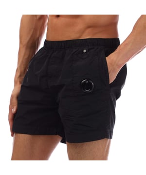 Mens C.P. Company Flatt Nylon Lens Swim Shorts in black.- Adjustable drawstring waistband.- Side pockets.- Lens detail.- Inner mesh.- Garment dyed.- Regular fit.- 100% Polyamide.- Ref: 18CMBW233A999