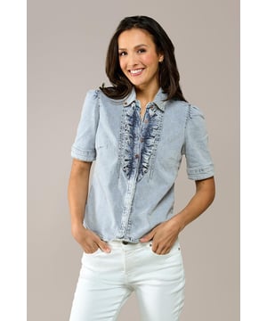 Ga deze zomer voor een trendy blouse met een denim look! Dit prachtige item uit mijn nieuwste collectie is een echte must-have voor een stijlvolle uitstraling. De blouse, uitgevoerd in een zachte lichtblauwe tint, heeft korte pofmouwen en een elegante opstaande kraag. De knoopsluiting is voorzien van speelse ruches, wat een subtiel vrouwelijke touch toevoegt. De getailleerde pasvorm en heuplengte flatteren je figuur op een natuurlijke manier. Gemaakt van biologisch katoen biedt deze blouse niet alleen stijl, maar ook ultiem comfort. Het stretchdenim vormt zich mooi naar je lichaam en benadrukt je vrouwelijke vormen. Verkrijgbaar in meerdere kleuren, zoals wit en mediumblauw.