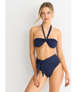 Indulge in luxury with our Navy Twist Front Halter Neck Bikini Top. The elegant twist detail and halter neck design exude sophistication and style. Made with high-quality materials, it offers comfort and support while flattering your figure. Perfect for a day by the pool or a tropical getaway.