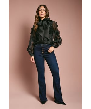 Exquisite organza blouse adorned with striking 3D flower appliqus
        Elegant collared neckline with feminine pussy bow detail
        Voluminous balloon sleeves for dramatic silhouette
        Semi-sheer finish with lined body for sophisticated coverage
        Button-through front design for classic styling
    
    This enchanting Coast blouse captures attention with its dimensional floral detailing and diaphanous organza fabric. The romantic balloon sleeves and graceful pussy bow create a silhouette that commands attention at any formal gathering. Style with wide-leg denim as shown for a contemporary twist on occasion dressing, or pair with a tailored pencil skirt and court shoes for wedding guest perfection. The translucent quality of the fabric creates an ethereal effect whilst the lined body ensures appropriate coverage. This versatile piece transitions beautifully from daytime events like the races to evening celebrations, making it an essential addition to your occasion wardrobe. The delicate craftsmanship and attention to detail reflect the sophisticated aesthetic Coast is renowned for.