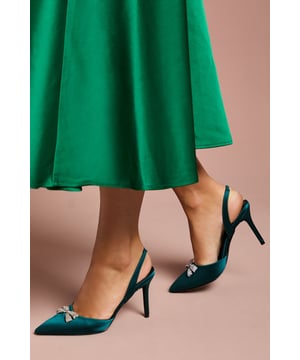 Elegant satin slingback court shoes featuring a stunning diamante bow brooch detail
        Pointed toe silhouette creates a flattering, elongated look
        Sophisticated 8cm stiletto heel adds height whilst maintaining comfort
        Wide fit design offers additional room for all-day wear
        Secure slingback strap with elasticated insert ensures the perfect fit
    
    The Scarlett slingback heels from Coast are the epitome of occasion-worthy footwear. These striking court shoes combine timeless elegance with contemporary flair, featuring a luxurious satin finish and eye-catching diamante bow brooch that catches the light beautifully with every step. The pointed toe and sleek stiletto heel create a refined silhouette that complements both midi and full-length gowns perfectly. Style with a tailored dress for a wedding or pair with a structured jumpsuit for the races. The wide fit construction ensures comfort throughout formal events, whilst the slingback design adds a touch of vintage charm. These versatile heels transition effortlessly from daytime ceremonies to evening receptions, making them a worthy investment for your special occasion wardrobe.