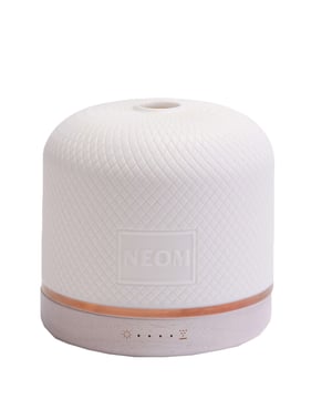 Experience ultimate relaxation and wellness with the Neom Wellbeing Pod Luxe, designed to elevate your wellbeing through scent. This premium essential oil diffuser is perfect for large spaces, creating a soothing atmosphere in your home or office. With remote control, customize mist intensity, light settings, and Breathing Mode for guided relaxation. Fill the 350ml water tank with cold water and your favorite NEOM Essential Oil Blend for up to 12 hours of aromatic bliss. The chic gravure ceramic cover and sustainable wooden base reflect your commitment to eco-friendly living.