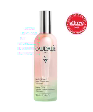 Revitalize your skin with Caudalie's Beauty Elixir, a versatile mist designed to prep and refresh your complexion. This iconic face mist doubles as a makeup setting spray and contains 100% natural ingredients like green grape, orange blossom, and essential oils such as peppermint and rose. Suitable for all skin types, it hydrates, calms, and tightens pores. Use it in your skincare routine or as a quick refresh. Loved by A-listers and makeup artists, this vegan formula is a handbag essential for a radiant glow. Enjoy a cooling sensation by storing it in the fridge.