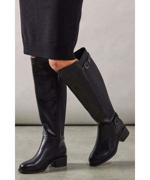 Extra wide fit design for exceptional comfort throughout the day
        Stretch back panel accommodates different calf widths
        Decorative buckle detailing at ankle and calf for a classic riding boot aesthetic
        Mid-height block heel measuring between 5-6.5cm for stable walking
        Knee-high silhouette with smooth faux leather finish
    
    These Koira riding boots from Good For The Sole combine timeless style with practical comfort. The extra wide fit and clever stretch back panel ensure a comfortable fit for various calf sizes, whilst the mid-height block heel offers stability without sacrificing style. Perfect for autumn through winter, pair these versatile boots with slim-fit trousers and an oversized jumper for weekend countryside walks, or style with a midi skirt and tights for casual family gatherings. The classic buckle detailing adds a refined touch to the silhouette, making these boots equally suitable for casual office environments when worn with tailored trousers. The knee-high design also works beautifully with denim and cosy knitwear for those relaxed coffee dates or shopping trips when comfort and style are equally important.