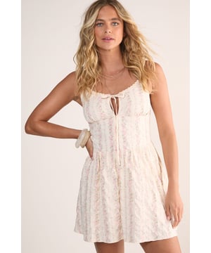 Textured seersucker fabric with delicate floral pattern throughout
        Feminine lace trim detailing along the neckline
        Adjustable tie-front closure for a customisable fit
        Flattering mini length with relaxed silhouette
        Comfortable strappy design with gathered bodice
    
    This charming Nasty Gal mini dress combines the classic texture of seersucker fabric with a sweet floral pattern for effortless daytime style. The delicate lace trim and tie-front detail add a touch of feminine flair, whilst the lightweight cotton construction ensures comfort during warmer days. Style with western boots for a contemporary countryside look, or pair with trainers and a denim jacket for casual brunches with friends. The versatile design makes it perfect for garden parties, picnics in the park, or relaxed family gatherings. Add layered necklaces and woven accessories to complete this carefree daytime ensemble. The gathered bodice creates a flattering shape that works beautifully for various casual occasions without requiring fussy styling-simply throw on and go for an instantly put-together summer look.