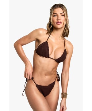 Intricately crocheted triangle bikini top with textured detailing
        Adjustable halter neck ties for a customised fit
        Side-tie bikini bottoms for versatile styling options
        Scalloped edges adding a delicate, feminine touch
        Minimal coverage design perfect for maximising your tan
    
    Make a statement poolside with this eye-catching crochet bikini from Boohoo. The textured triangle top offers light support while the tie-side bottoms allow for adjustable comfort throughout the day. Perfect for beach holidays and pool parties alike, this bikini pairs beautifully with oversized sunglasses and stacked bracelets as shown by our model. For a complete resort look, throw on a sheer kaftan and slide sandals when heading to the beach bar. The distinctive crochet texture creates visual interest that stands out from standard swimwear, making this a must-have addition to your holiday wardrobe. Whether lounging on a sunbed or taking a dip in the ocean, this bikini combines fashion-forward design with practical beachwear functionality.