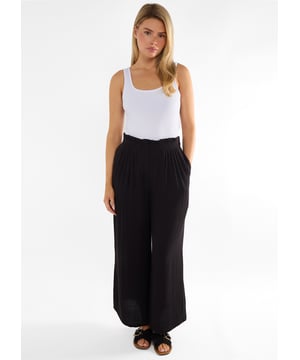 Moeiteloos chique zwarte Paperbag Waist broek met wijde pijpen die comfort en stijl toevoegt aan je garderobe. Het flatterende ontwerp met hoge taille sluit aan in het midden terwijl de wijde pijpen een dramatisch silhouet creëren. Perfect om aan te kleden met hakken of casual te houden met gympen - deze veelzijdige broek gaat de hele dag met je mee.