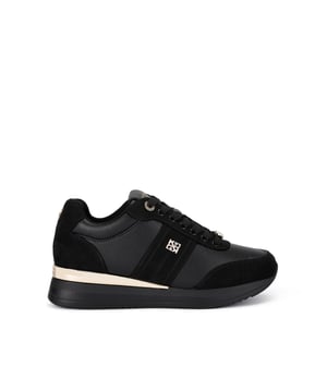 The KG Kurt Geiger Lina Lace Up Sneaker features a black upper with gold tone accents. At the back of the sole there is a large, branded gold panel as well as a KG Kurt Geiger branded pin stud on the outer side of the shoe.