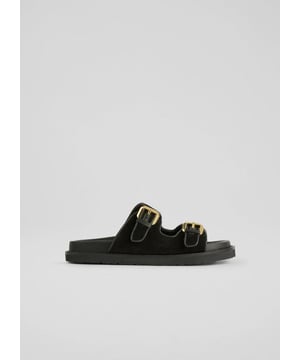 Revealing the Capri sandals, featuring their double strap design and gold buckle detail, crafted from soft black suede. These sandals promise comfort with a moulded footbed and support in every step. Ideal for a sunny brunch or a leisurely day out, pair them with a flowing summer dress or casual jeans for a stylish look.