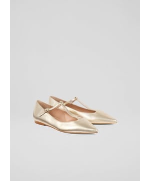 Our stunning 'Drew' flats are crafted in Spain from luxurious gold metallic leather. These T-bar flats feature a pointed toe and gleaming gold colour. Perfectly pair them with tailored trousers for a polished look or a flowing skirt for a touch of whimsy. Ideal for brunch dates, office days, or leisurely strolls around town.