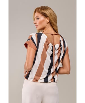 De Benza Print top in zwart en crème is de perfecte combinatie van stijl en veelzijdigheid. Dit jersey ontwerp uit de nieuwste collectie van Mart Visser valt op door zijn klassieke zwart-crème blokstrepenprint. De watervalhals aan de achterkant geeft een speelse, maar toch elegante touch aan het design. Dankzij het luxe materiaal en de aangesneden mouwen is deze top zowel geschikt voor formele als casual gelegenheden. De rechtvallende pasvorm en de heuplengte zorgen voor een flatterend silhouet en ultiem draagcomfort. Deze top is ideaal voor dagelijks gebruik en laat je altijd stijlvol voor de dag komen. De tijdloze blokstrepenprint maakt combineren eenvoudig: draag hem met een jeans en sneakers voor een casual look of combineer hem met een pantalon of rok en hakken of enkellaarsjes voor een chique, zakelijke uitstraling.