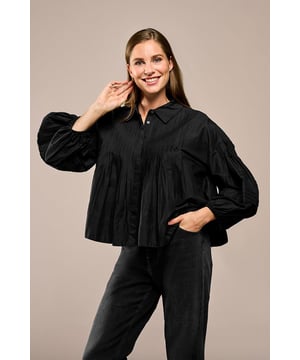 Maak kennis met jouw nieuwe favoriet: de Alice Blouse Zwart, een stijlvolle en tijdloze blouse die perfect is voor de lente en zomer. Een klassieke basisblouse met een trendy twist! Deze veelzijdige blouse is gemaakt van 100% katoen, wat zorgt voor een licht, ademend materiaal dat optimaal draagcomfort biedt. De blouse heeft een oversized pasvorm met elegante pofmouwen, wat zorgt voor een moderne en verfijnde uitstraling. Wat deze blouse echt bijzonder maakt, zijn de unieke plooidetails: de verticale plooien aan de voor- en achterzijde en de subtiele horizontale plooien op de mouwen geven de blouse een speelse en interessante twist. De klassieke kraag en blinde knoopsluiting maken deze blouse een tijdloze klassieker. Naast zwart is deze must-have ook beschikbaar in wit, zodat je altijd de perfecte optie hebt die bij jouw stijl past.