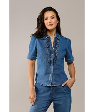 Kies deze zomer voor een trendy blouse met een denim uitstraling! Dit stijlvolle item uit mijn nieuwste collectie is een perfecte basis voor elke outfit. De blouse in mediumblauw heeft korte pofmouwen en een elegante hoge kraag. De knoopsluiting in het midden is afgewerkt met een speelse ruche, wat zorgt voor een charmante twist. Dankzij de getailleerde pasvorm en de heuplengte accentueert de blouse je silhouet op een flatterende manier. Gemaakt van biologisch katoen biedt deze zomerse blouse niet alleen stijl, maar ook ultiem comfort. Het stretchdenim vormt zich mooi naar je lichaam en benadrukt je vrouwelijke vormen. Ontdek ook de Brighton denim blouse in wit en lichtblauw!