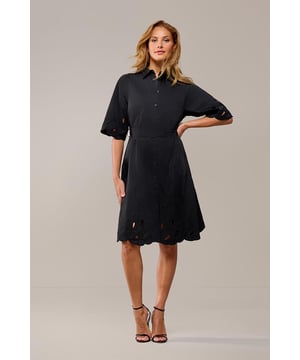 e Teddy tuniek is de perfecte mix van stijl en veelzijdigheid voor je garderobe. Deze zwarte tuniek, met verfijnde borduurseldetails op de mouwen en zoom, heeft een tijdloze charme. De uitlopende rok en subtiele accenten maken het een uitstekende keuze voor allerlei gelegenheden, van informele bijeenkomsten tot formele evenementen. Dankzij de doorknoopsluiting aan de voorkant kun je de tuniek zowel open als dicht dragen, zodat je hem kunt afstemmen op je eigen stijl. De strikceintuur in de taille benadrukt je figuur en zorgt voor een vrouwelijke pasvorm. Met zijn lengte tot op de knie en comfortabele driekwartmouwen biedt de Teddy tuniek zowel stijl als functionaliteit. Het A-lijn silhouet en de licht getailleerde pasvorm zorgen ervoor dat deze tuniek mooi staat bij ieder figuur. De tijdloze zwarte kleur maakt de Teddy tuniek eenvoudig te combineren met allerlei accessoires en schoenen. Voor een casual look draag je de tuniek met sneakers en een spijkerjack. Wil je het wat chiquer? Combineer de tuniek dan met hakken en verfijnde sieraden.