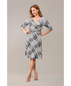 De July print jurk is de perfecte combinatie van comfort en stijl. Deze elegante jurk is voorzien van een prachtig grafisch patroon in zwart en crème, wat direct de aandacht trekt. Met een V-hals met overslag en een strikceintuur die de taille benadrukt, heeft de jurk een verfijnde uitstraling. Of je nu naar kantoor gaat of een speciale gelegenheid hebt, deze jurk is ideaal voor elke gelegenheid. De vrouwelijke pasvorm is getailleerd en sluit mooi aan met een lange blinde rits aan de achterkant. De driekwartmouwen maken de jurk geschikt voor elk seizoen, en op koudere dagen kun je hem perfect combineren met een mooie blazer. De knielange lengte creëert een klassieke en tijdloze look. Het materiaal, bestaande uit 95% polyester en 5% elastaan, voelt zacht aan en heeft een lichte stretch, zodat je je gemakkelijk kunt bewegen. De voering zorgt ervoor dat de jurk niet doorschijnt en draagt bij aan het comfort.