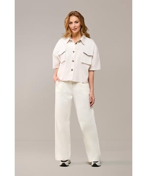 De Lina Blouse is een absolute must-have en een echte blikvanger. In deze offwhite kleur straal je een unieke en elegante stijl uit. Het klassieke ontwerp is vernieuwd met een modern design. Het oversized model heeft een losse pasvorm die soepel langs het lichaam valt en zorgt voor een ontspannen, casual gevoel bij je verfijnde look. Aan de voorkant van de blouse zitten opgestikte zakken aan beide kanten, terwijl de plooi op de achterkant een subtiel en elegant detail toevoegt. De bruingemêleerde knopen geven de blouse een speelse finishing touch. Met afhangende mouwen en een lengte tot op de heup biedt deze katoenen blouse een tijdloze uitstraling die je eindeloos kunt combineren. Daarnaast is de blouse ook verkrijgbaar in denim blauw en olijfgroen, zodat je altijd een perfecte match vindt voor jouw stijl.